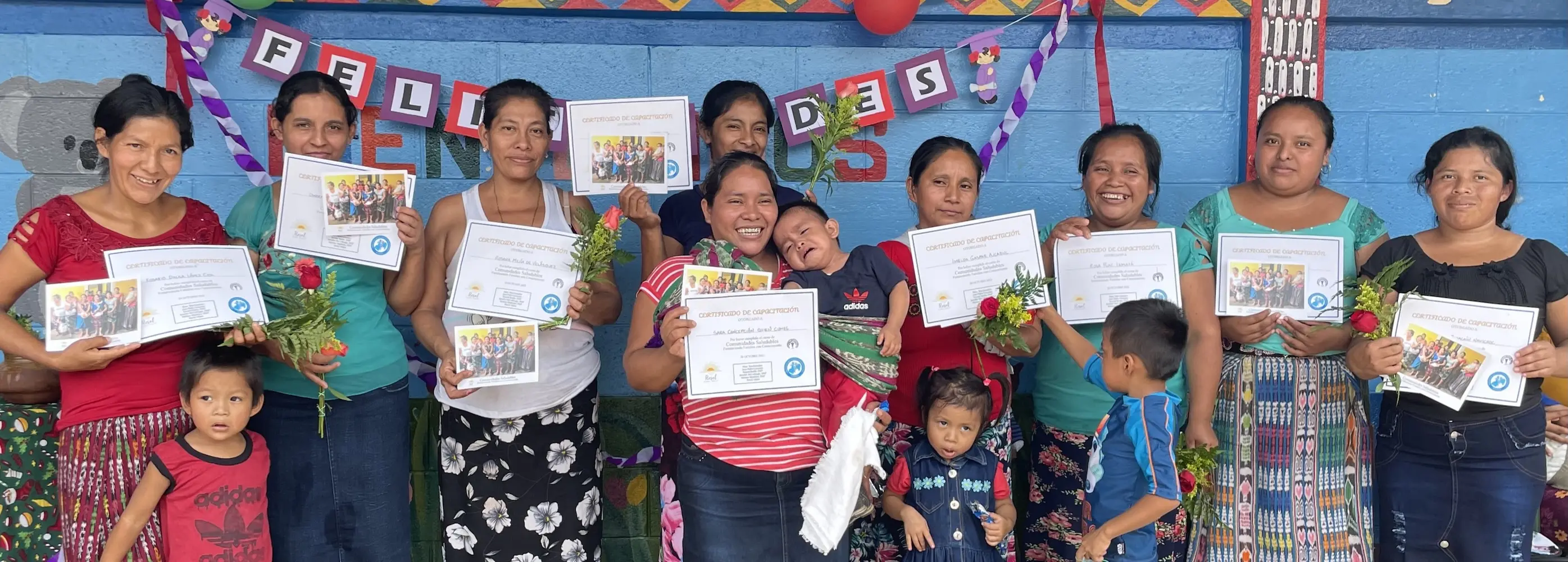 Graduates of a community health education program standing together in rural Guatemala